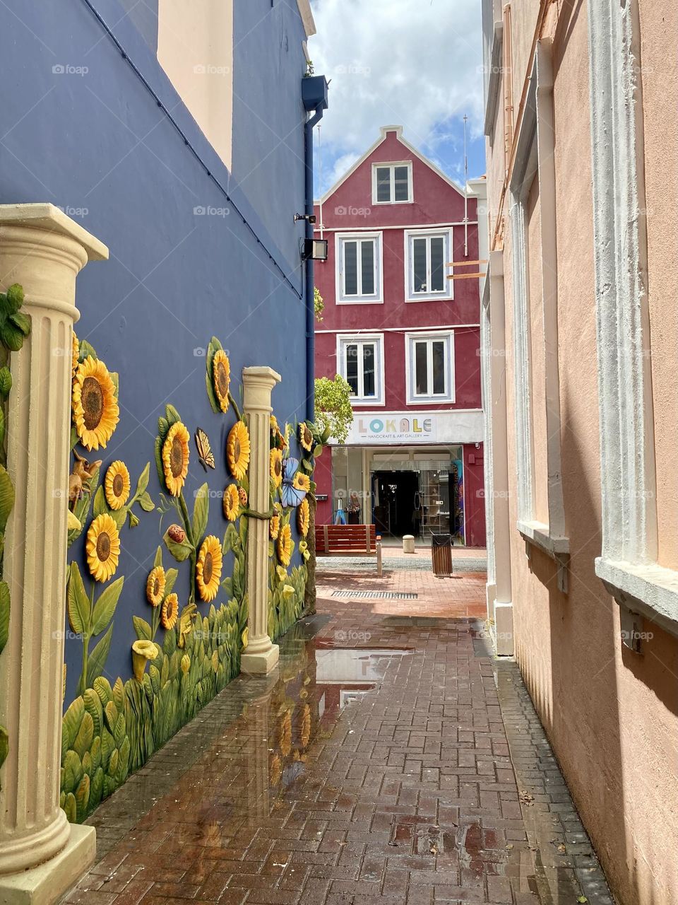 A colorful sunflower mural on the wall of an alley in downtown Willemstad Curacao