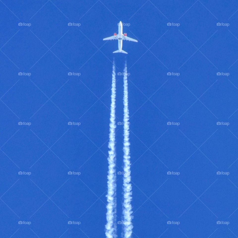 Airplane in blue sky. Vapor trails, Boeing 737 from Scandinavian Airways Systems SAS