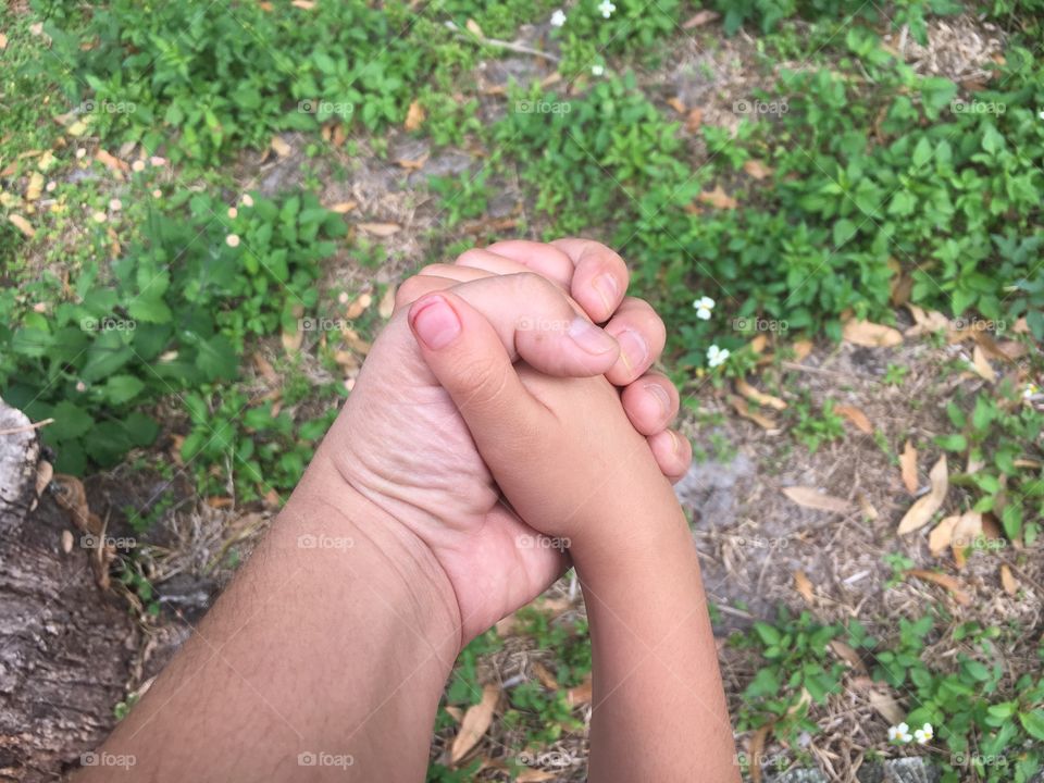Close-up of father and child holding hand