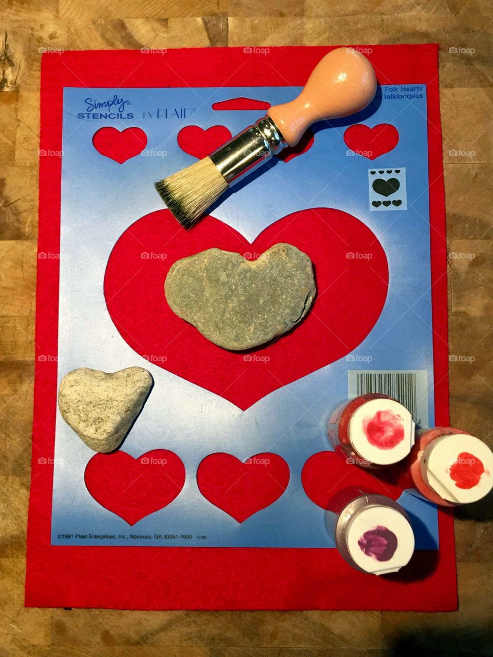 Stencil & Supplies for hearts stenciled in different colored paints. Stencil brush, heart shaped rocks for fun & paints.