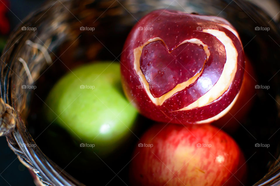 Good health apple harvest three apples in basket, red, green and multi colored with symbolic red heart design on apple conceptual of eating an apple a day to increase health and maintain healthy diet 