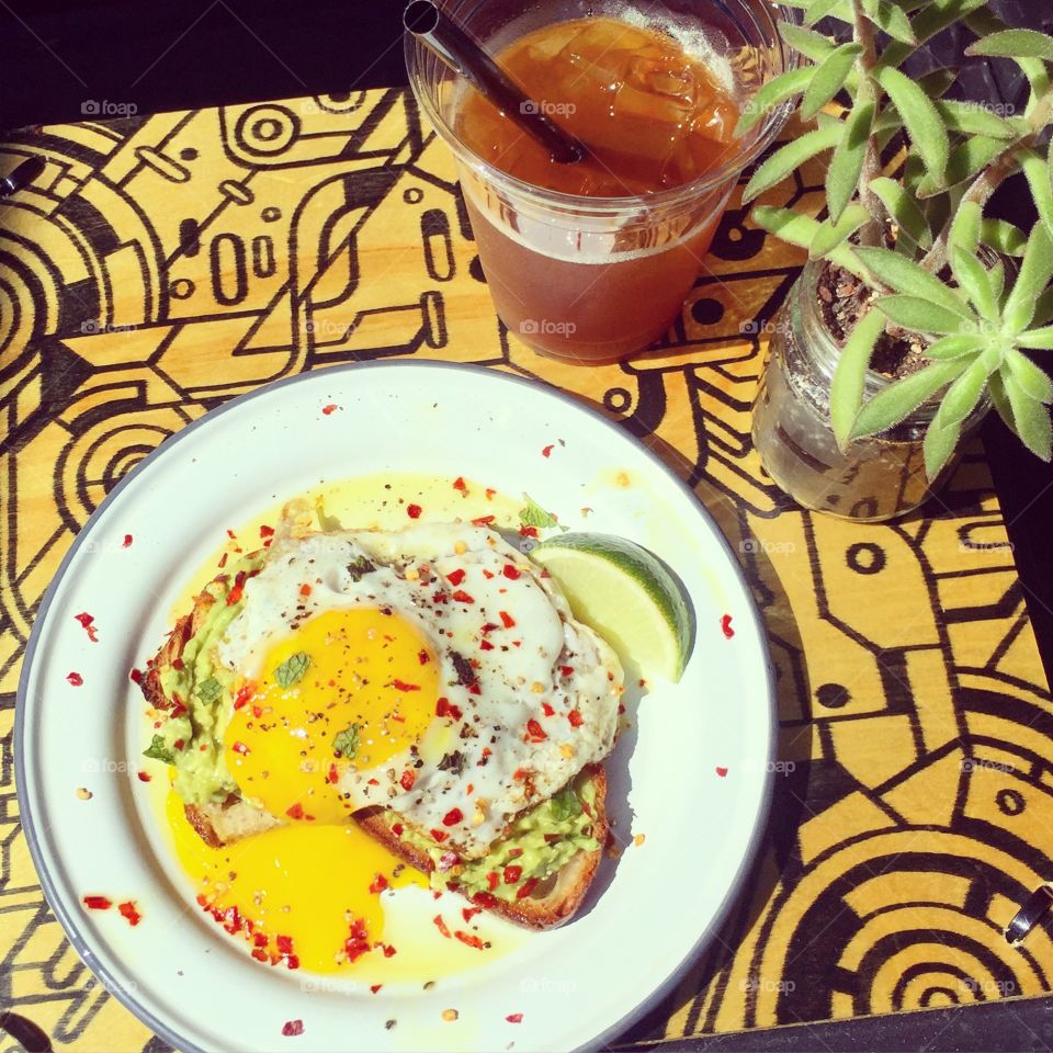 Eggs and coffee. Coffee and avocado toast topped with a runny egg