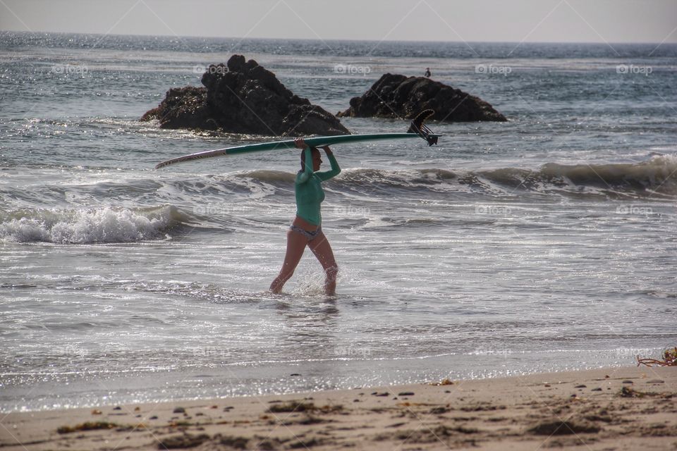A women holding surfboard on beach