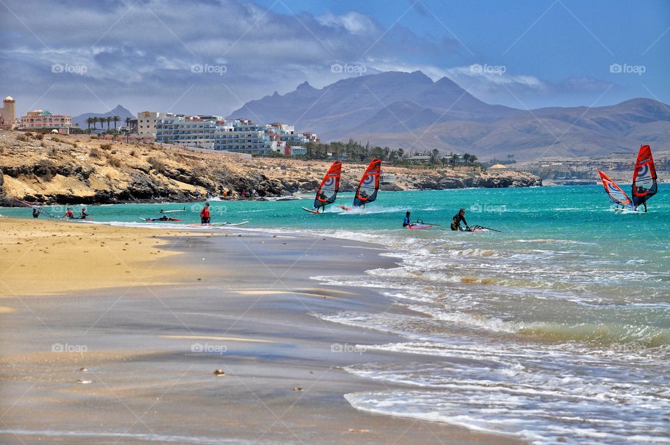 windsurfing in costa calma on fuerteventura canary island in spain - mountain and resort view