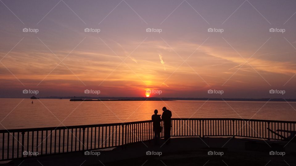 couple enjoyimg sunset. couple enjoying sunset