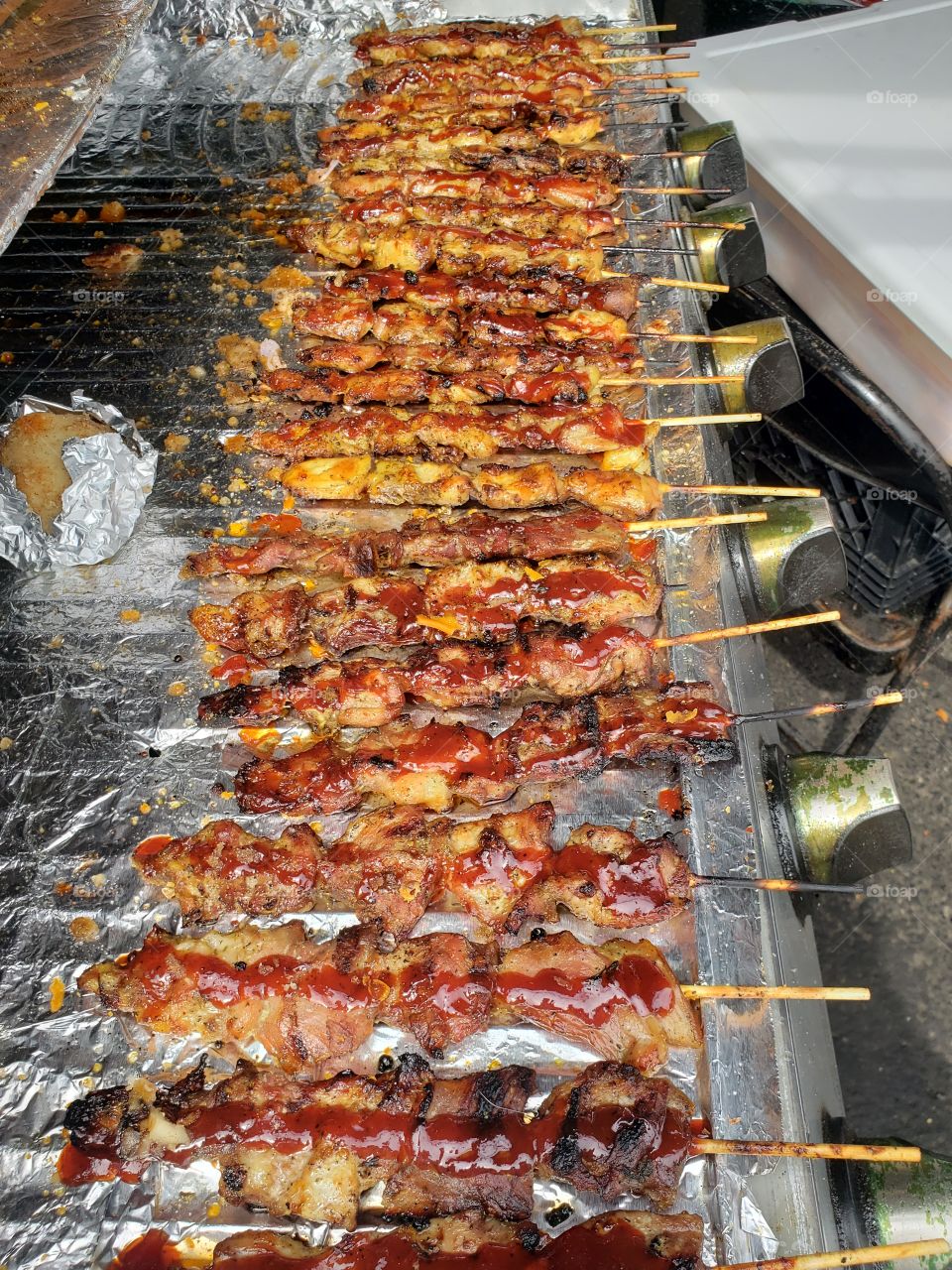 Dozens of shish kebab meat cooking on a barbecue