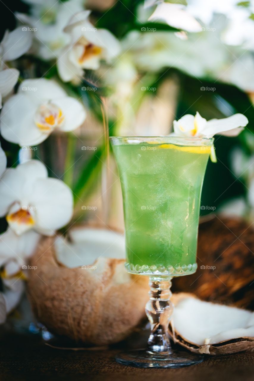 Tropical vacation cocktail with white orchids and coconut 