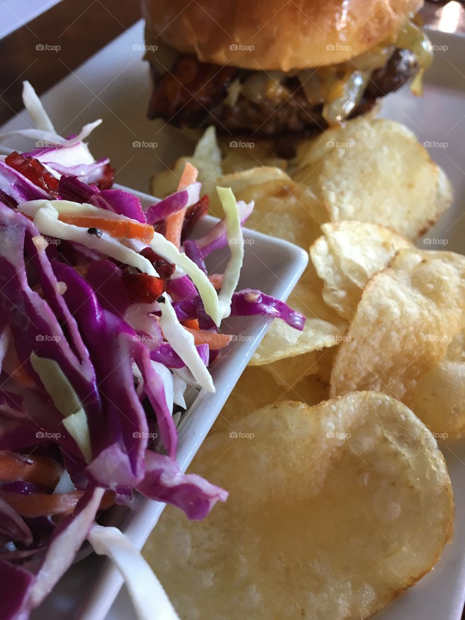 Cole slaw, potato chips and cheeseburger 