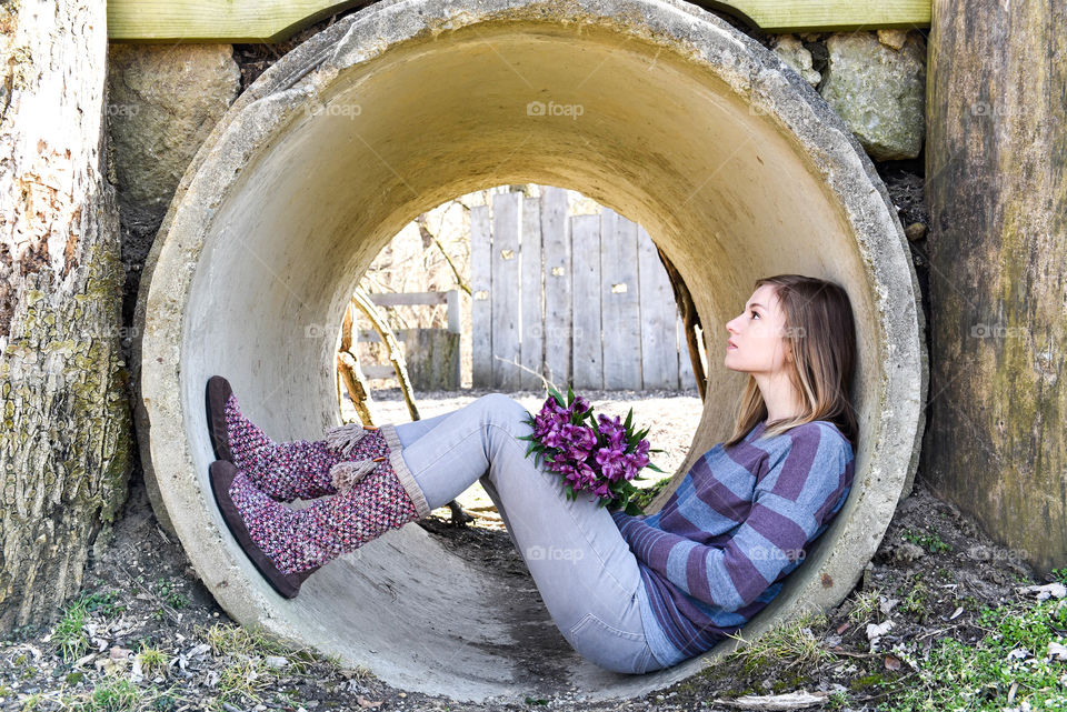 Portrait of a millennial woman sitting in a round cement tunnel