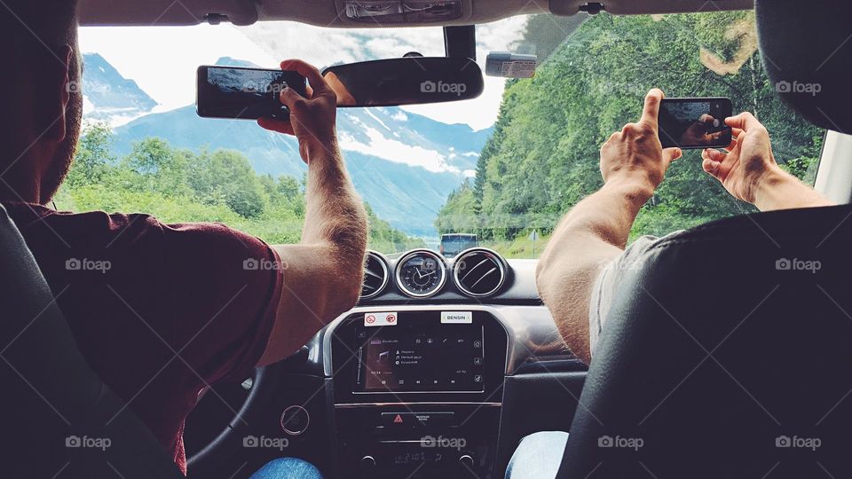 Excited driver taking shots while driving a car in the mountains of Norway. Warning: it’s illegal and can be dangerous! Don’t repeat in real life.