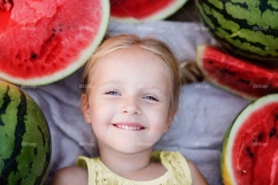 Cute little girl with blonde hair and watermelon 