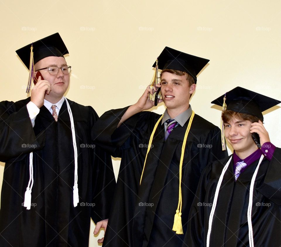 Graduates using their phone