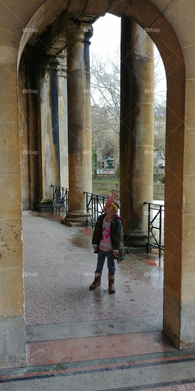 little girl looking up at arches of building