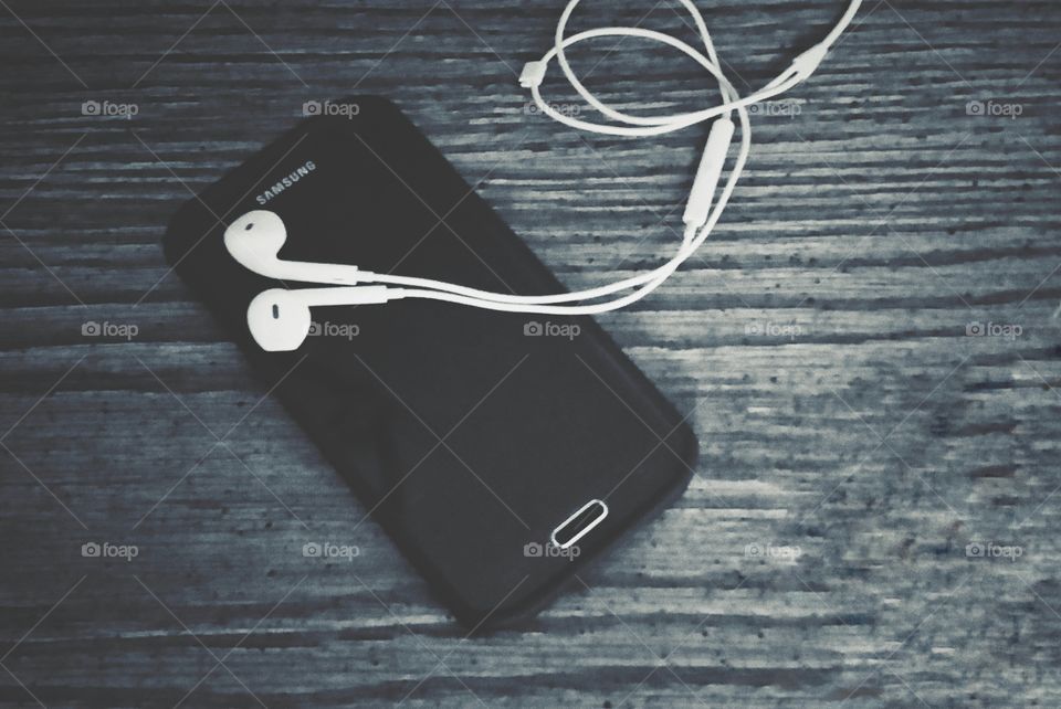 cell phone with ear buds listening to music