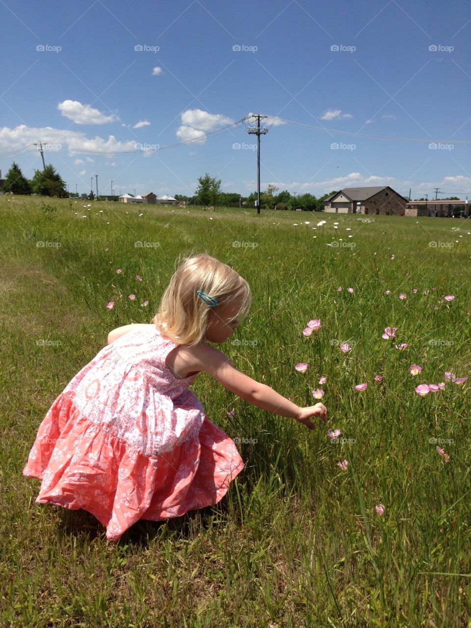 Girl picking up flowers from field