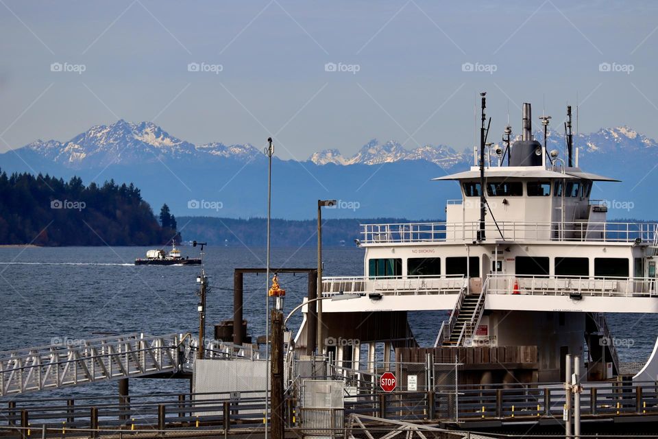 The ferry docks in Steilacoom, Washington while it waits for the next group of commuters to board, Olympic Mountain Range in the distance 