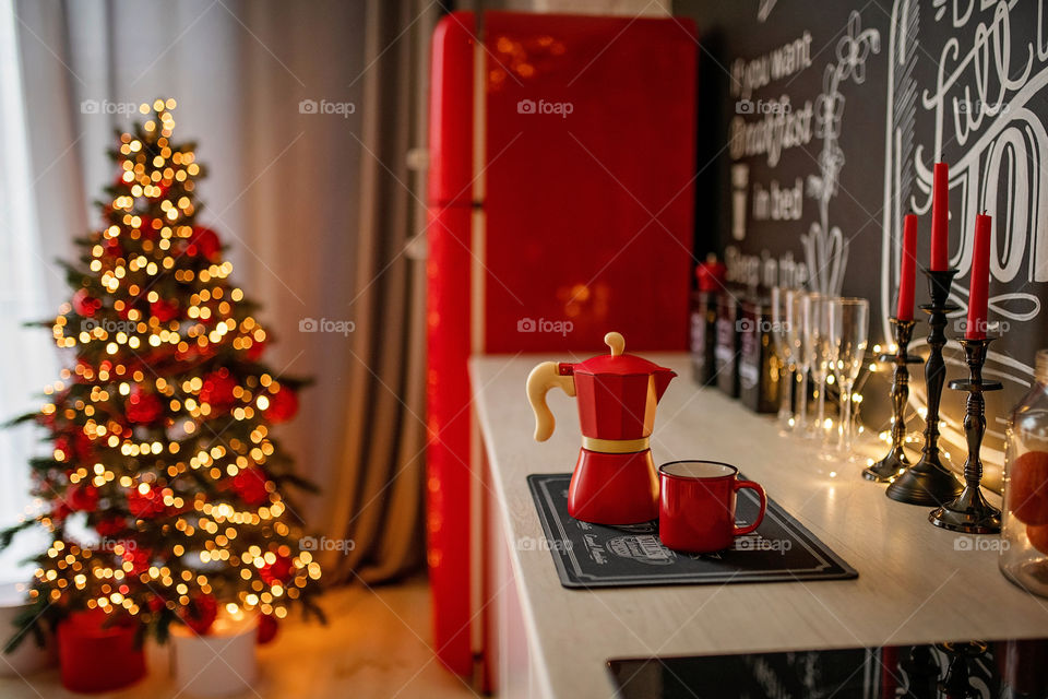 Festive winter cozy kitchen interior with garlands, decorations and gifts.  Christmas dinner at the decorated table.