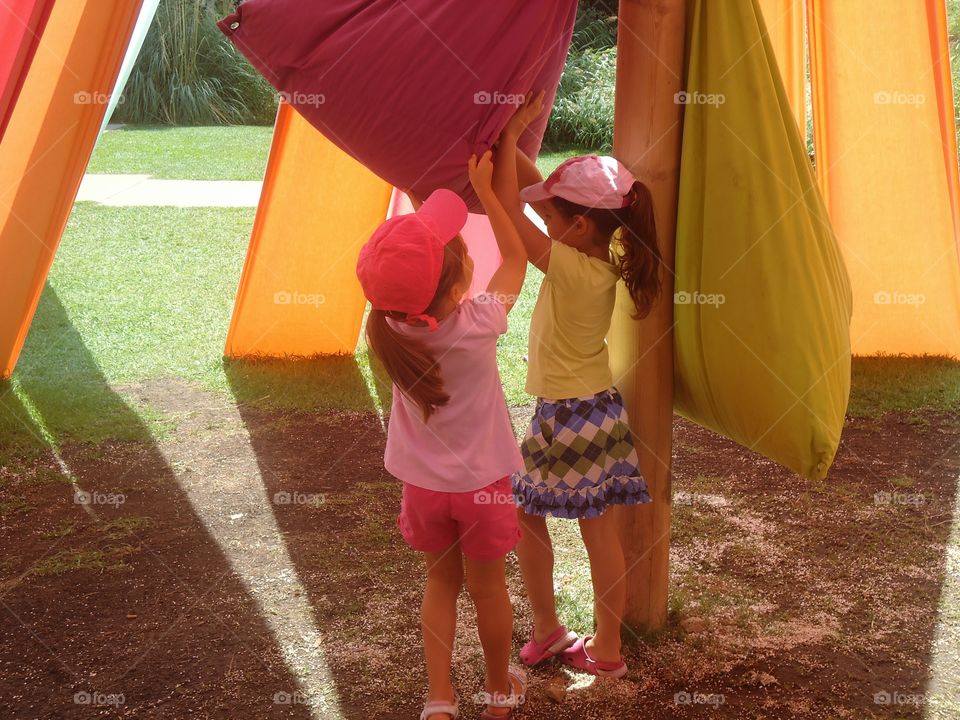 Two kids playing with a colourful bag