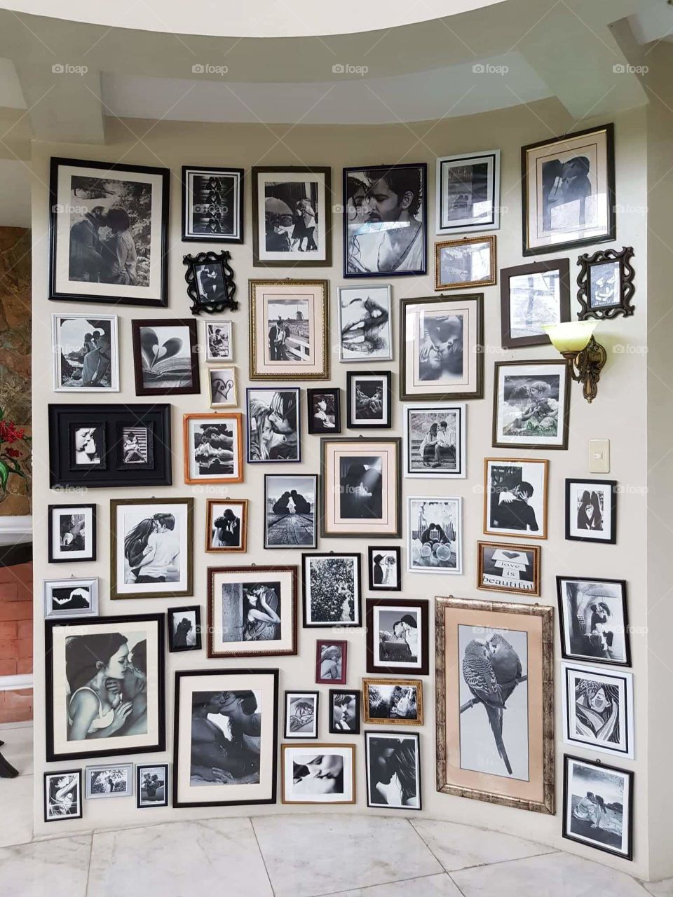 Collections of amazing photographs with frames pinned on wall. All those framed arts express love and affection.