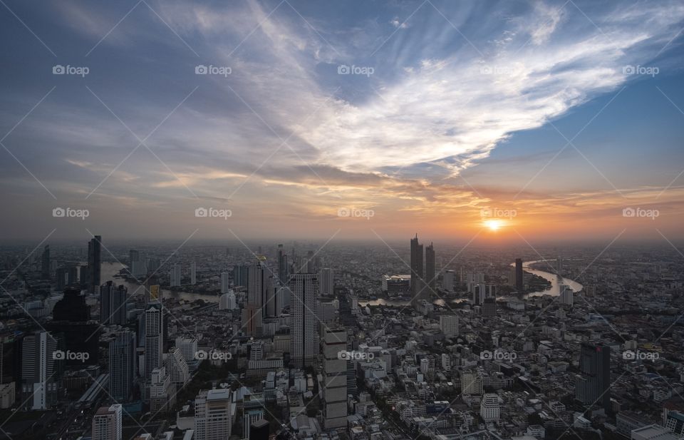Beautiful light of Sunset shade over the Chao Phraya River and Building in the big city , take photo from MahaNakhon tower , Bangkok Thailand