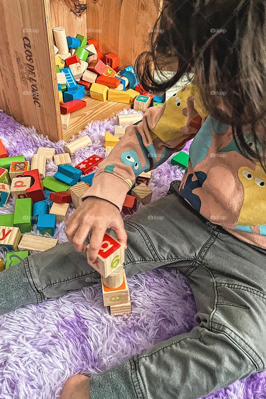 Toddler building with blocks, toddler girl playing with blocks, indoor activities in the winter, having fun inside, getting creative with kids, creating with toddlers, playing with blocks, wooden block building