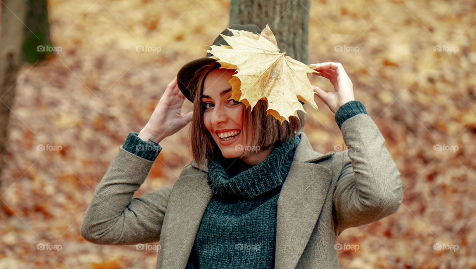 girl wearing a hat with yellow leaves