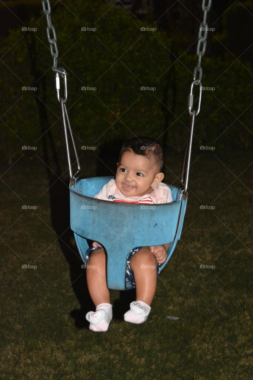 Baby girl in the Swing for first time Mixed emotions of Shocked and happiness