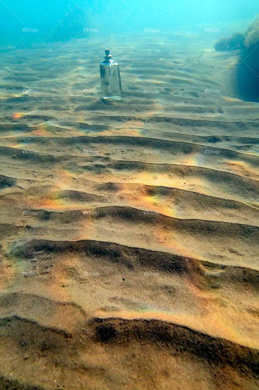 parfum bottle and sand dunes underwater