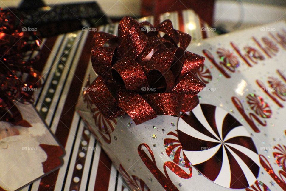 Red and white wrapping paper on presents. One present with stripes the other says “Ho Ho Ho” 