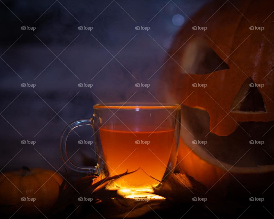 A glowing glass of hot cider in a Fall setting