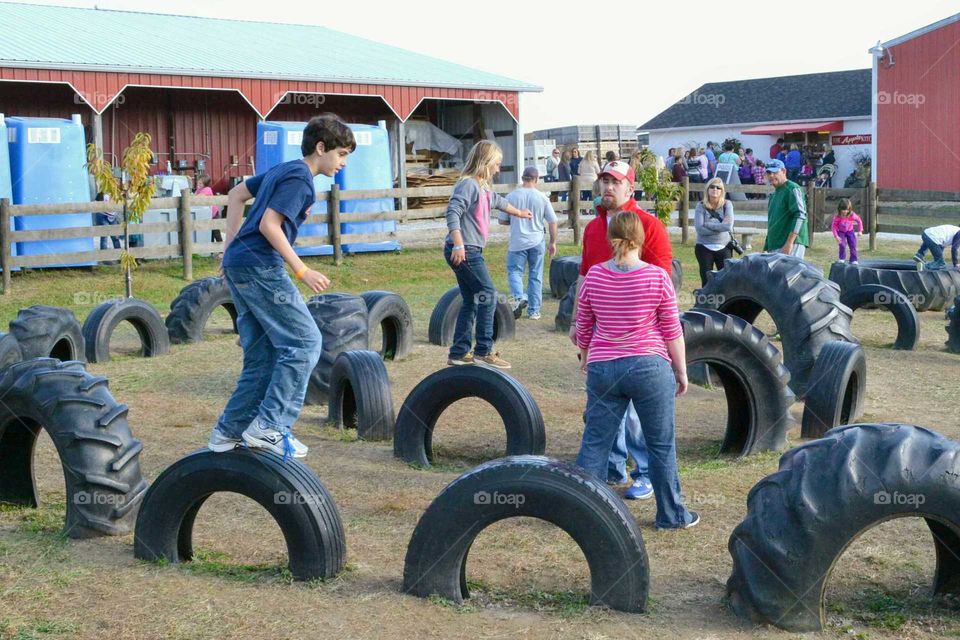 Kids playing jumping tractor tires