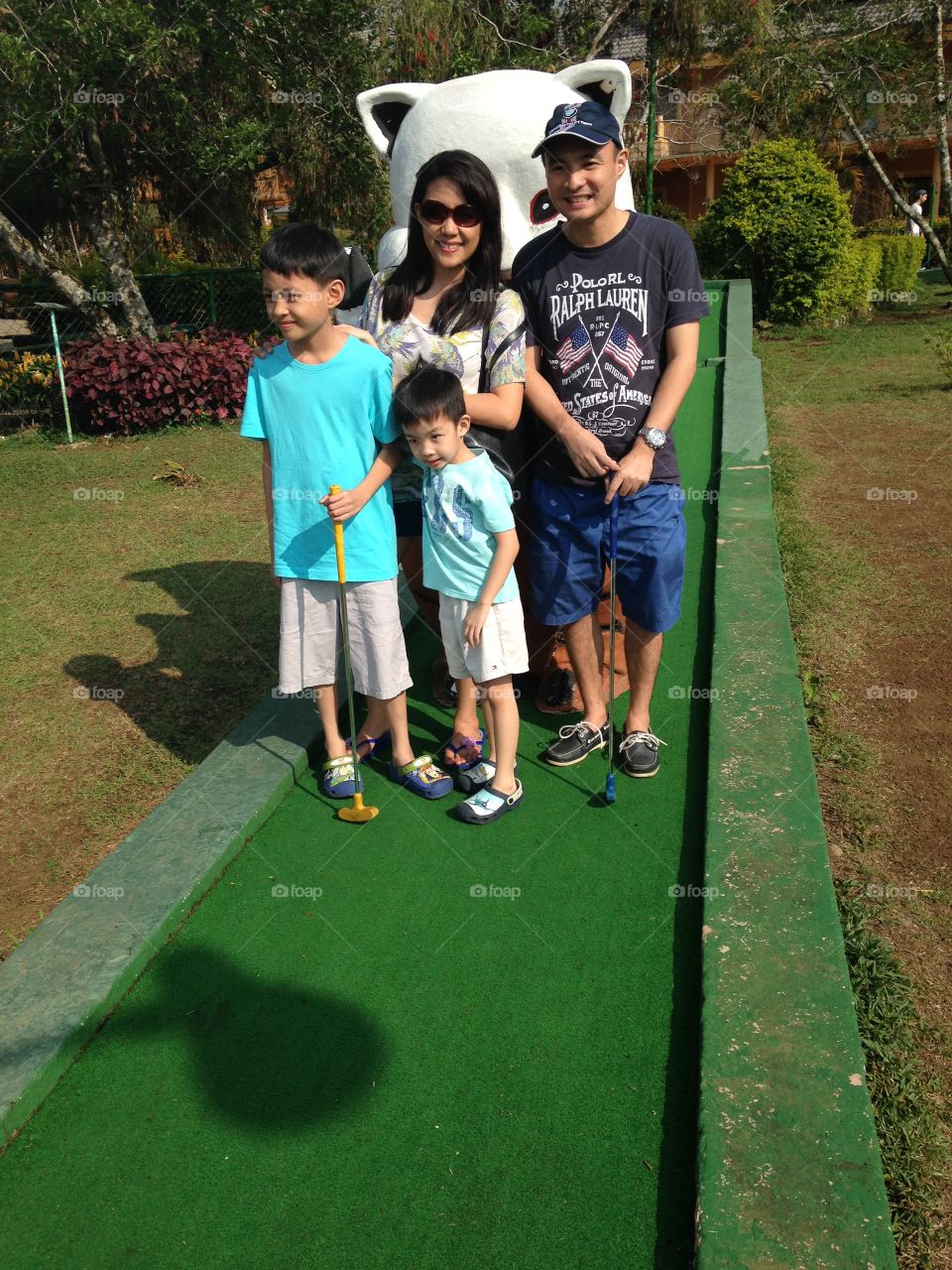 my son and his wife with their two sons playing in a mini golf range inside the resort