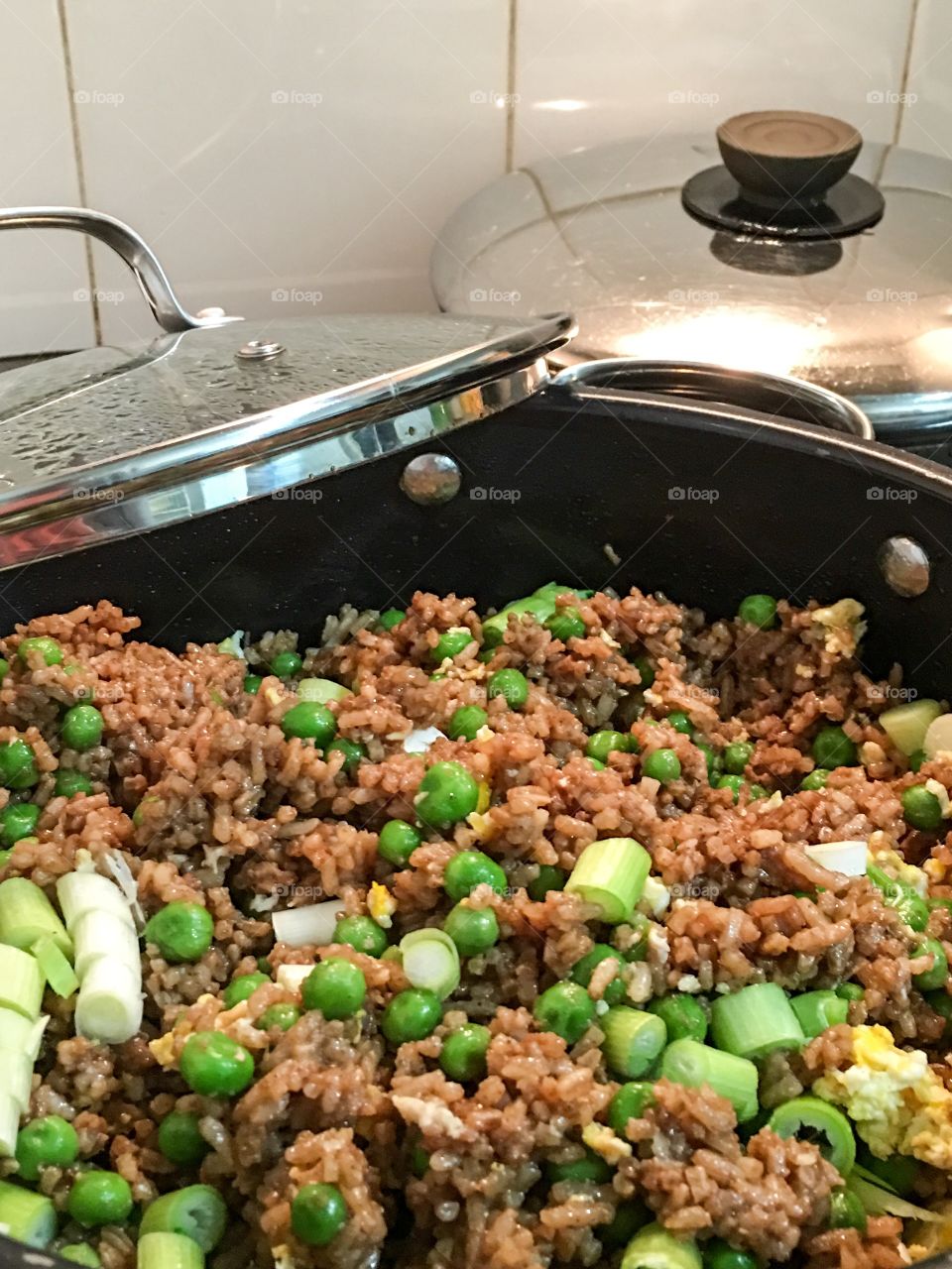 Chinese fried rice atop stove in cooking pan