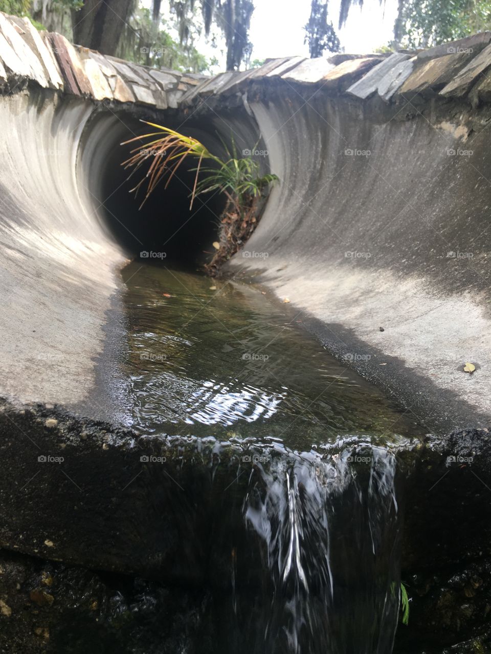 Water running through a pipe outdoors 