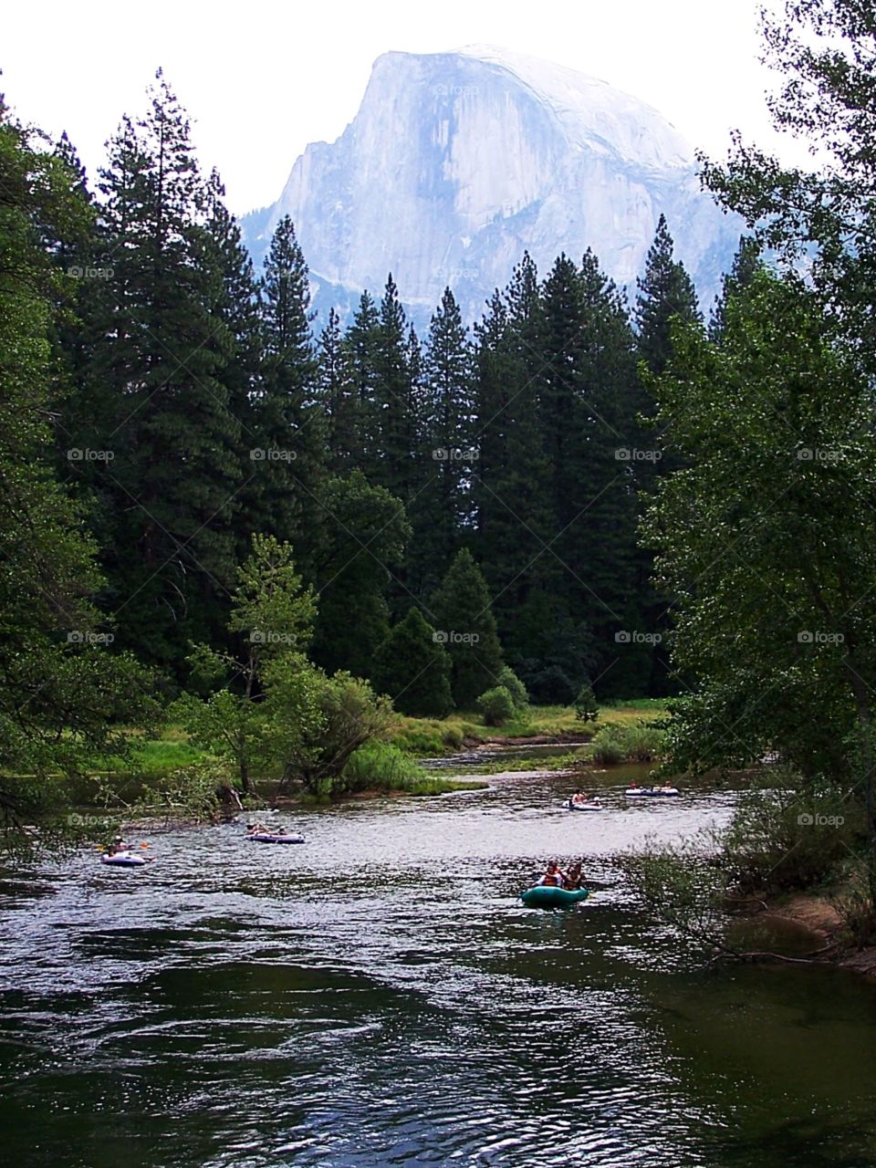 Rafters on the river in Yosemite beneath the shadow of El Capitan