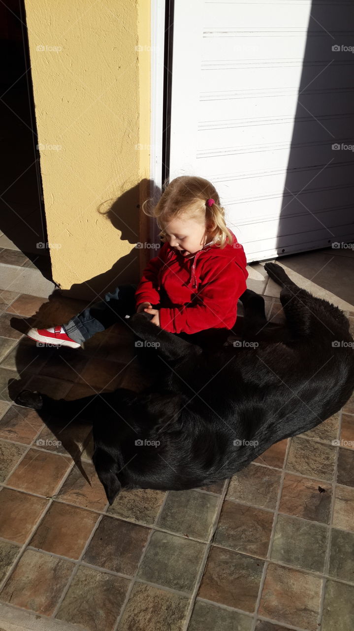 little girl caressing a street dog