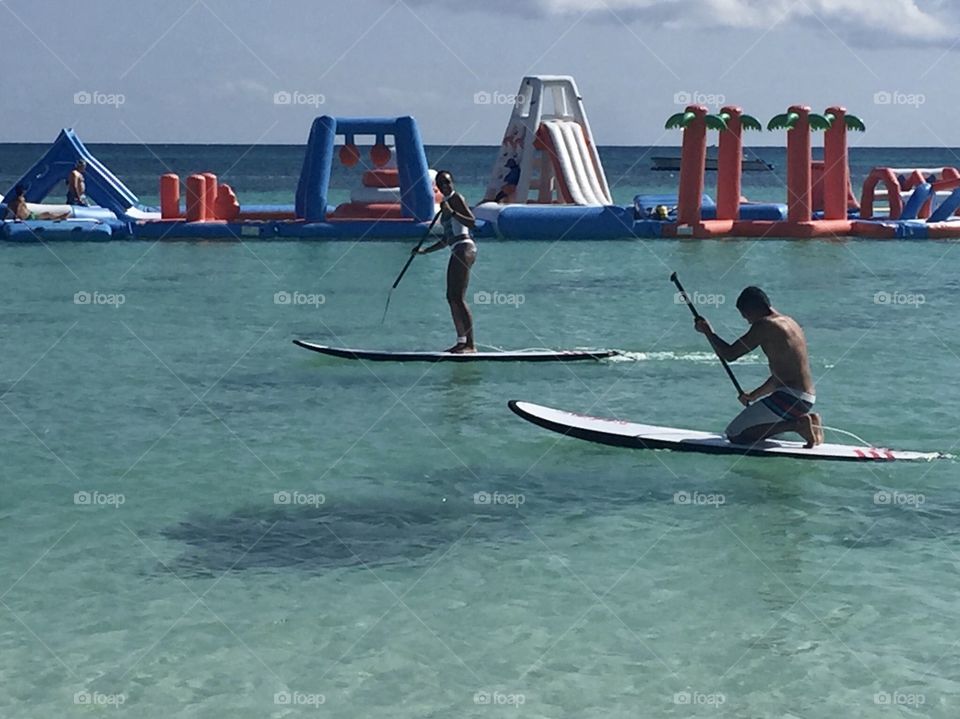 Two people Paddle boarding near the aqua park