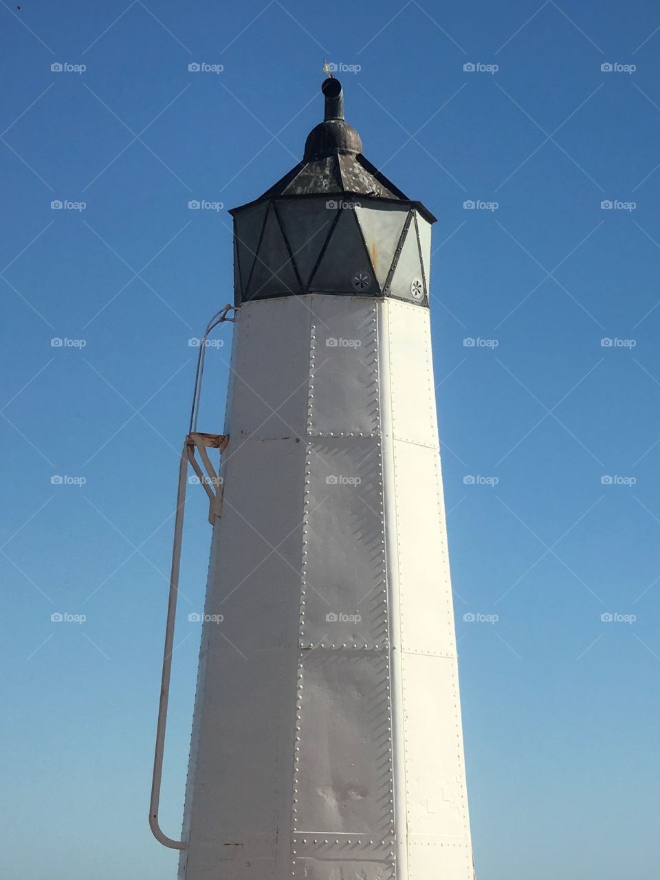 Old tin lighthouse against an indigo blue sky conceptual, minimalistic, space for text copy 