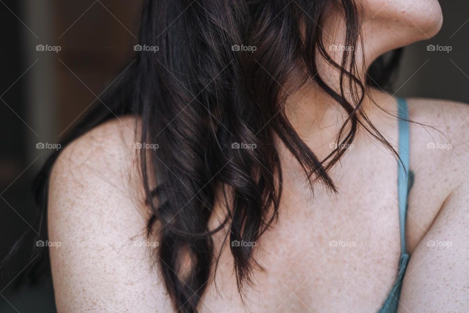 Brunette woman’s skin with freckles 