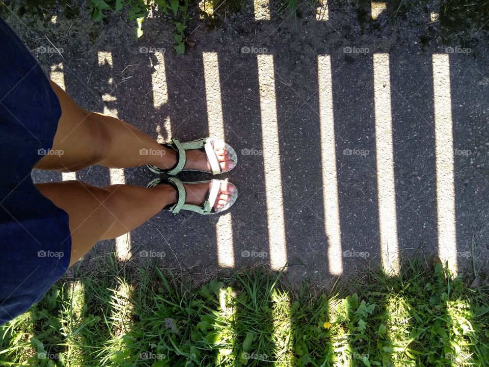 female legs top view walk on a street summer time