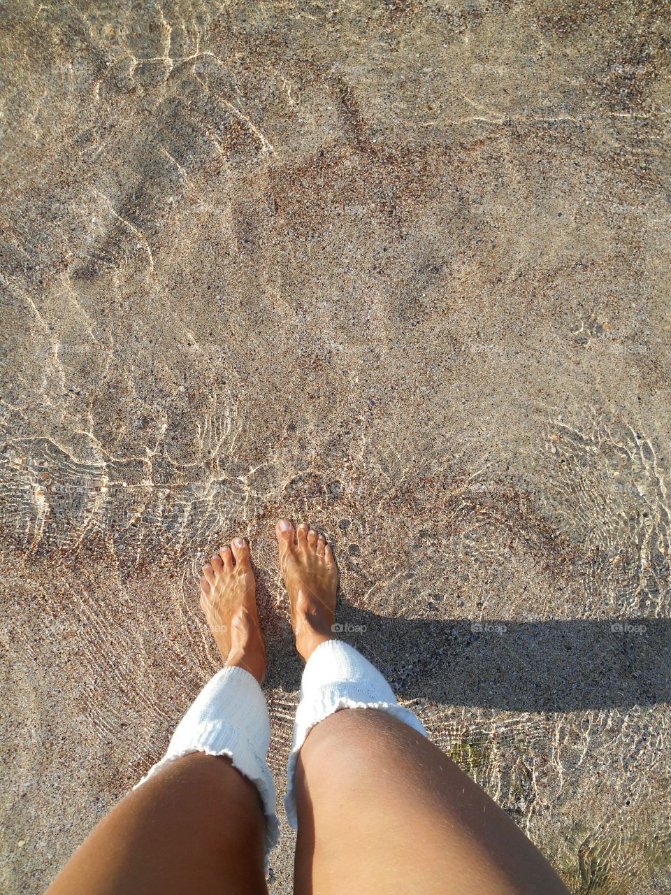 female legs on a sea clear water texture