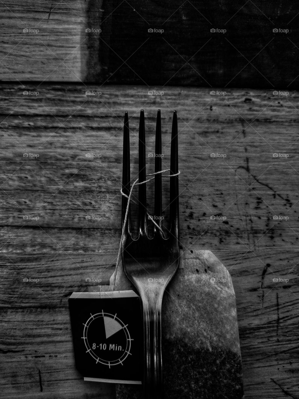 A black and white photo of an ordinary fork with a tea bag on it captured in an unordinary way