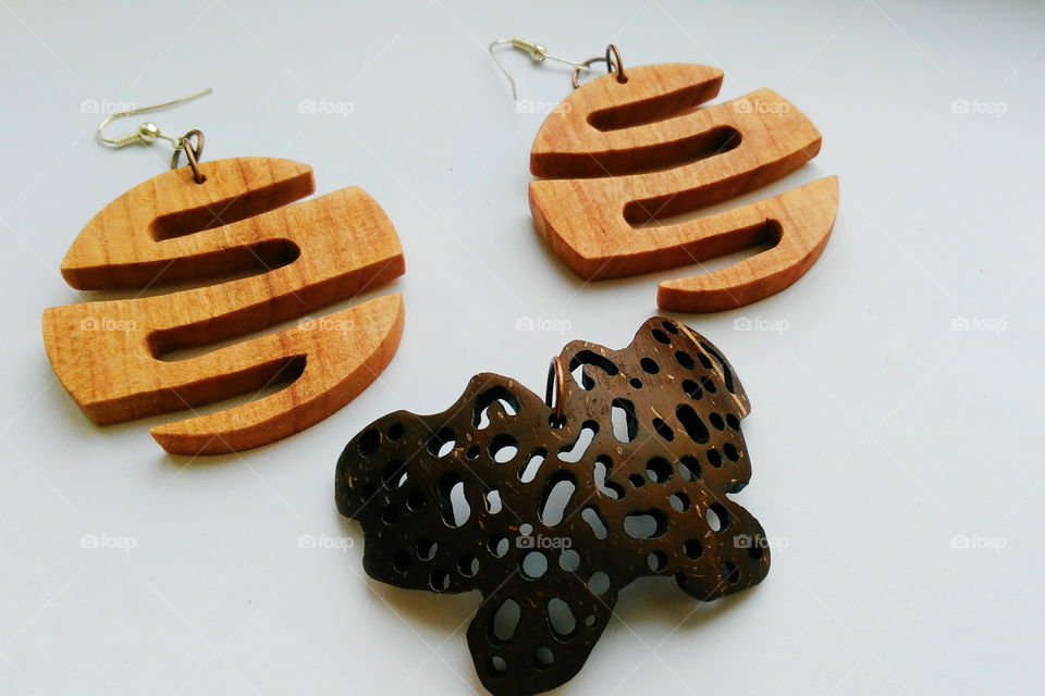 earrings made of wood and a pendant butterfly made of coconut on a white background