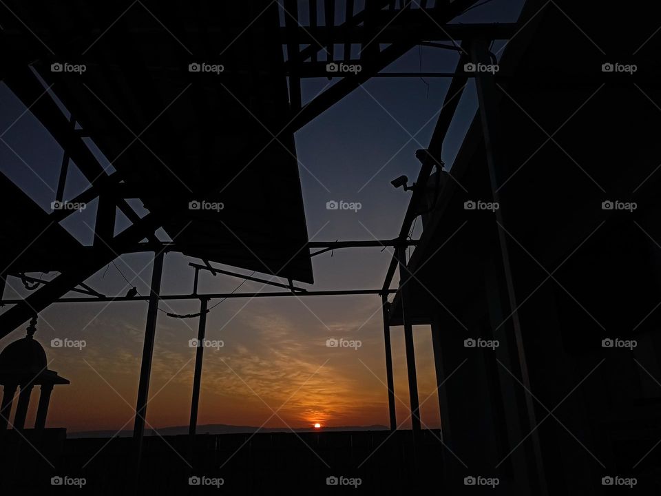 sun rise view from hostel terrace, you can see pigeon solar plates and cctv camera