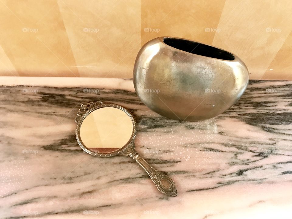 Vase and small mirror on the table 