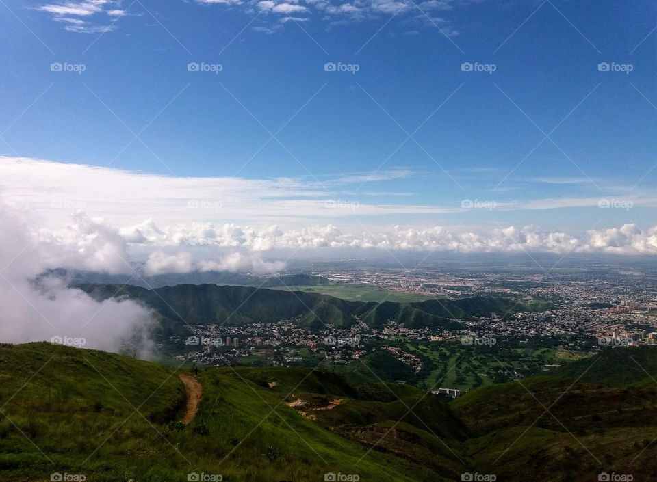 white clouds like tide, blue sky and beautiful landscape where you can see the city