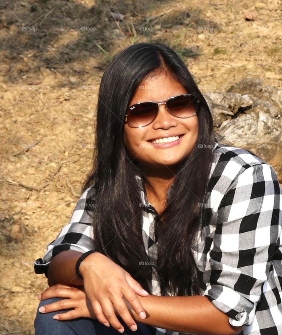 Girl with long black hair wearing sunglasses 