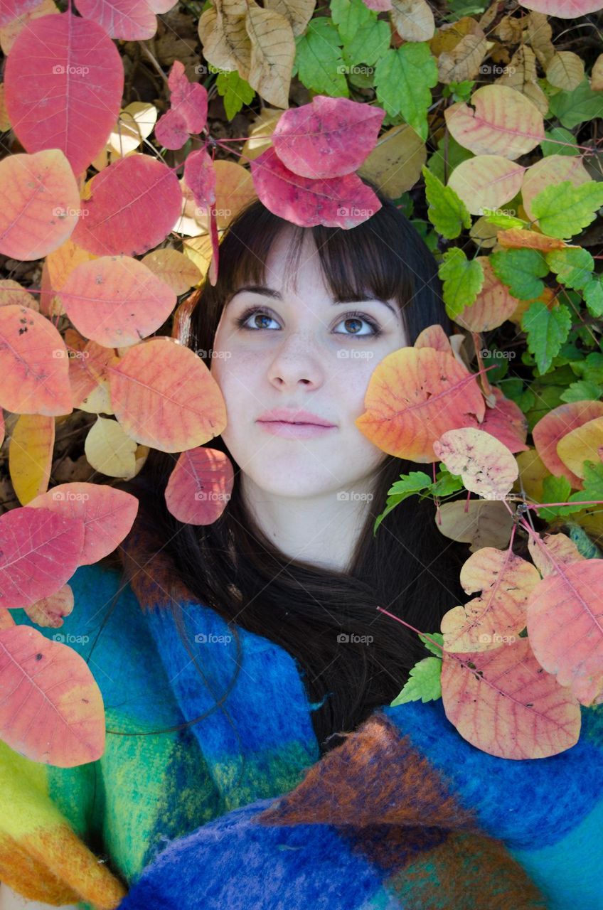 Autumn portrait of woman brunette on leaves background