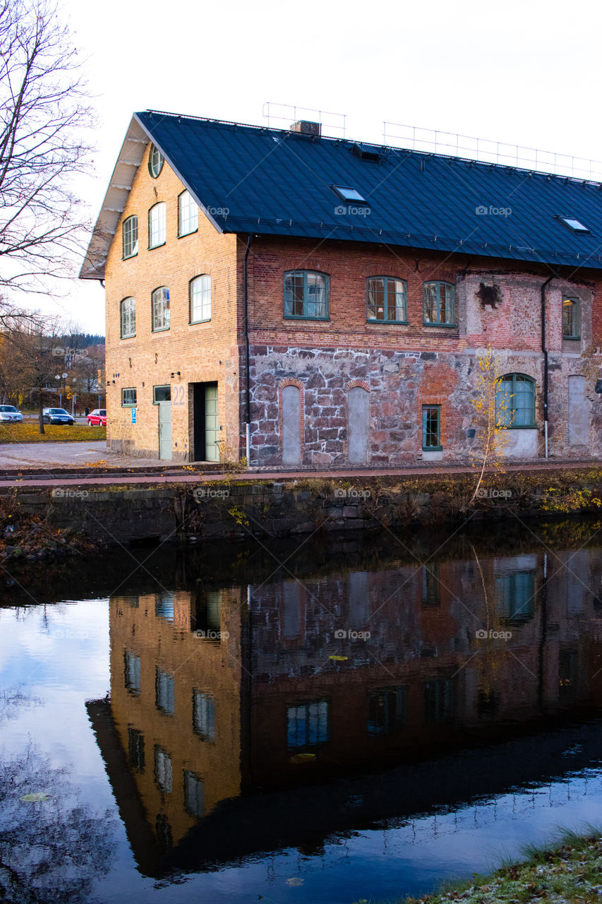 old brick warehouse along the river in Borås Sweden. nice reflection on the dark cold water