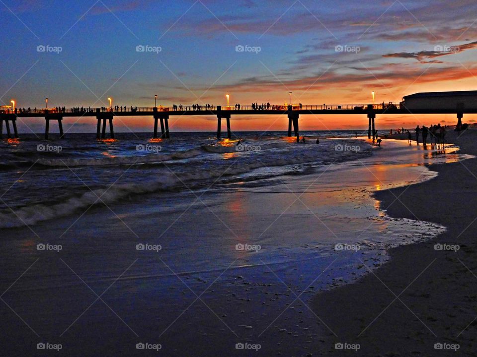 The evening sunset lighted up the fishing pier over the Gulf of Mexico. The radiance of the descending sunset was glorious to behold, and increasing every moment in splendor